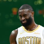 “Boston Celtics guard Jaylen Brown on the court as injury concerns arise before Raptors matchup.”