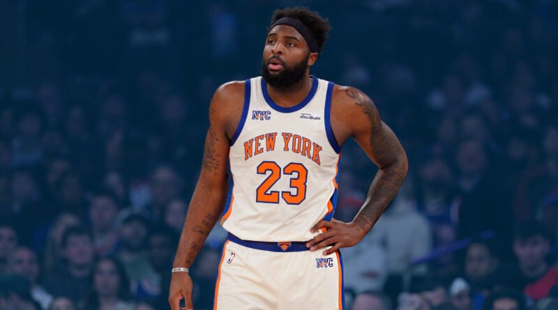 “New York Knicks center Mitchell Robinson battling for a rebound during a home game at Madison Square Garden.”